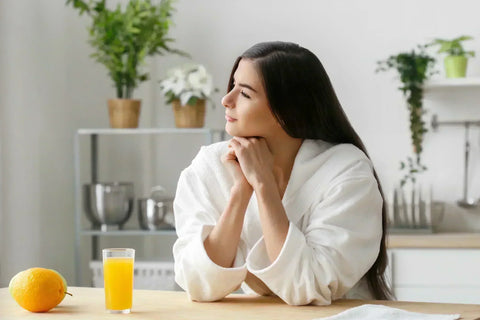 Woman in robe with orange juice