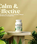 Supplement bottle labeled Serene Sleep on a wooden stand with greenery and text about its effects.