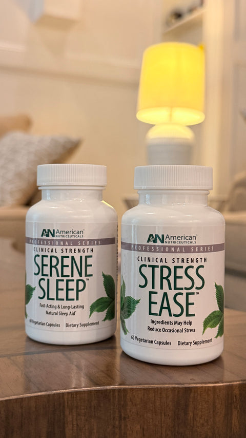 Two white supplement bottles labeled 'Serene Sleep' and 'Stress Ease', sitting on a wooden table with a warm, softly blurred home interior in the background.