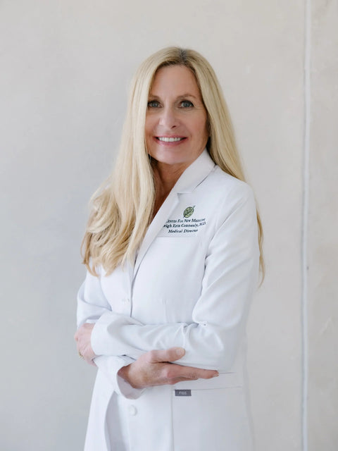 Woman wearing a white lab coat with a logo on a light background
